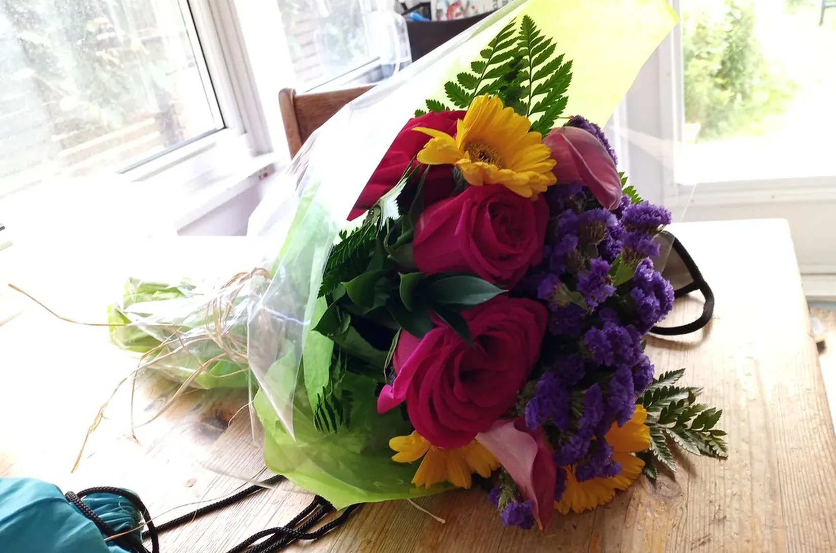 A medium hand-tied bouquet wrapped in paper on the worktable